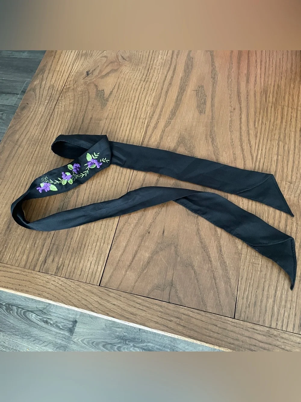 Black cloth hair scarf with purple floral embroidery and green leaves